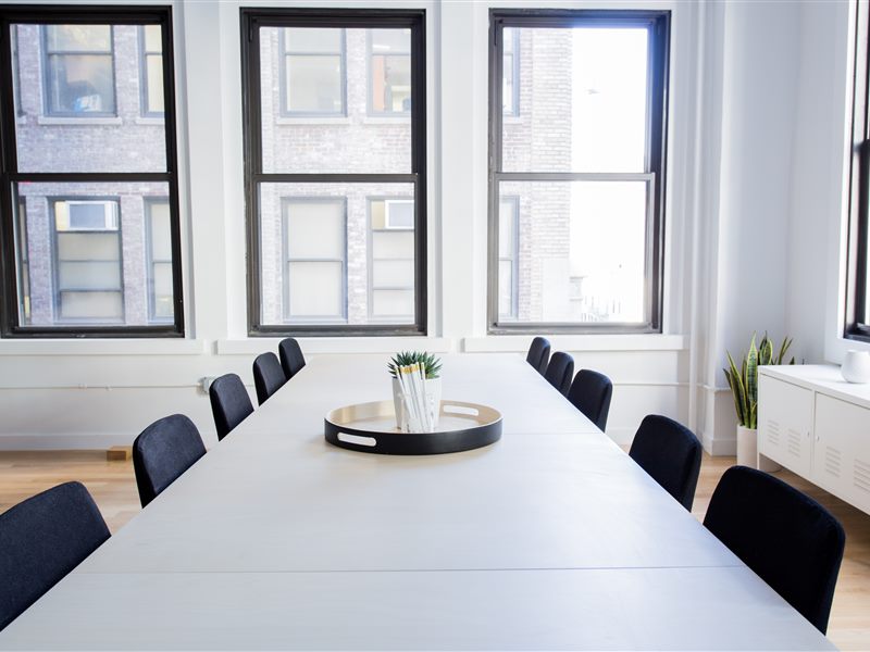 Modern meeting room with large table and wall-mounted display